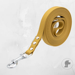 Yellow dog leash with metal clip on a light gray background