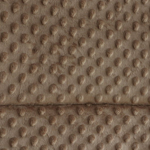Close-up of a textured faux fur or microfiber fabric with a raised circular dot pattern in warm taupe and brown tones.