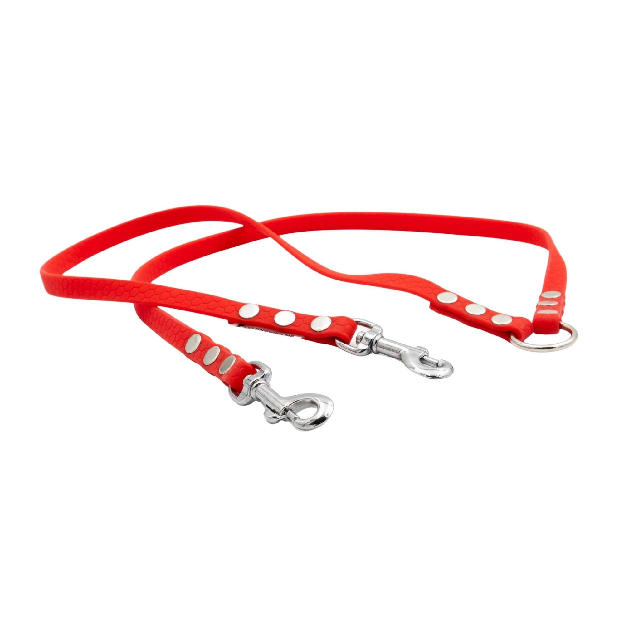 Red dog leash with silver clips on a white background