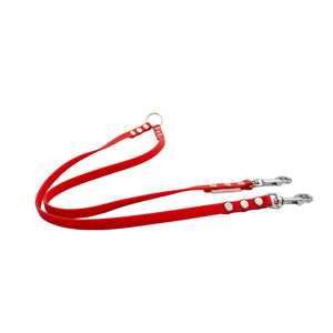 Red dog leash with white polka dots and metal clips on a white background