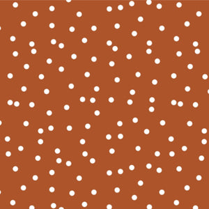 Close-up of the Terracotta Dots pattern with white polka dots on a warm terracotta background.