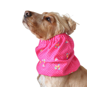Golden English Cocker Spaniel wearing a bright pink cotton snood with vintage roosters, tiny flowers and white dots.