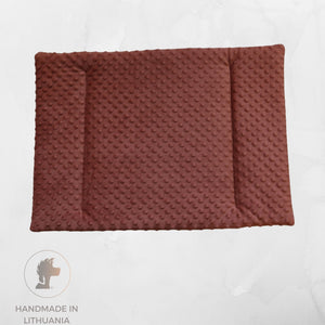 A rectangular brown textured pet mat with raised circular dots, shown from above on a light gray background. A circular logo at the bottom left reads 'HANDMADE IN LITHUANIA' with a stylized lion head icon.