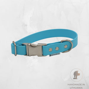A bright turquoise blue pet collar with a silver metal quick-release buckle, shown on a light gray textured background. A small brand tag reading 'SIAUJIAUSKA M.