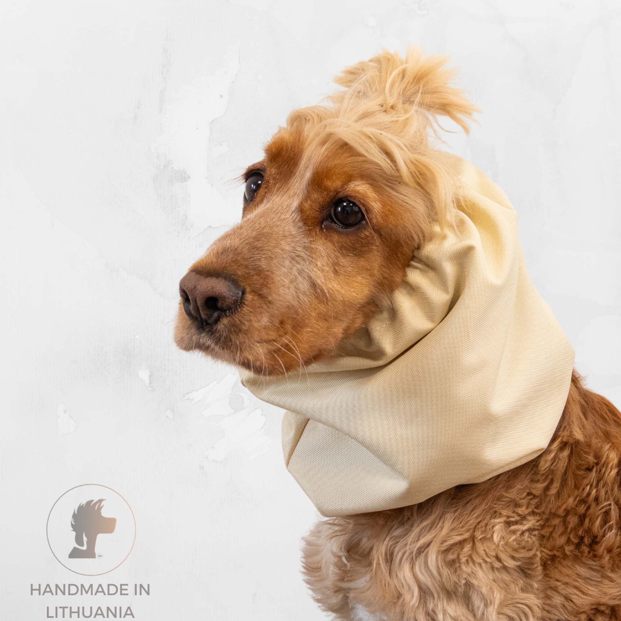 Dog wearing a beige neck wrap on a light gray background with 'Handmade in Lithuania' label.