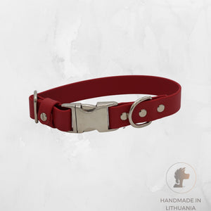 A red biothane dog collar with a silver metal buckle, D-ring, and rivets, displayed on a light gray textured background with a 'Handmade in Lithuania' logo in the bottom right corner.