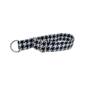 Black and white houndstooth patterned dog collar with a silver buckle on a white background